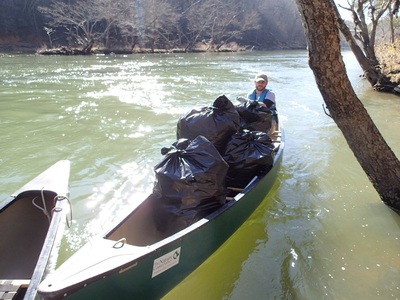 VISTA in canoe with bags of trash