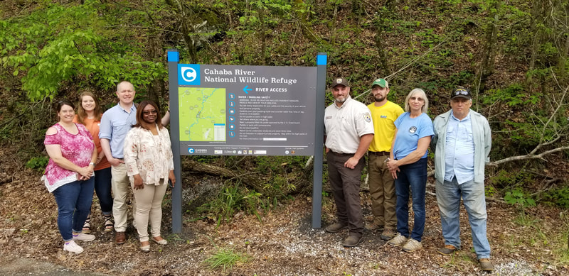 Six people standing next to upright sign Cahaba River National Wildlife Refuge