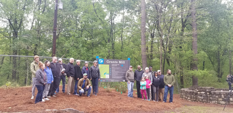 People standing next to up right sign Cahaba Blueway Grants Mill