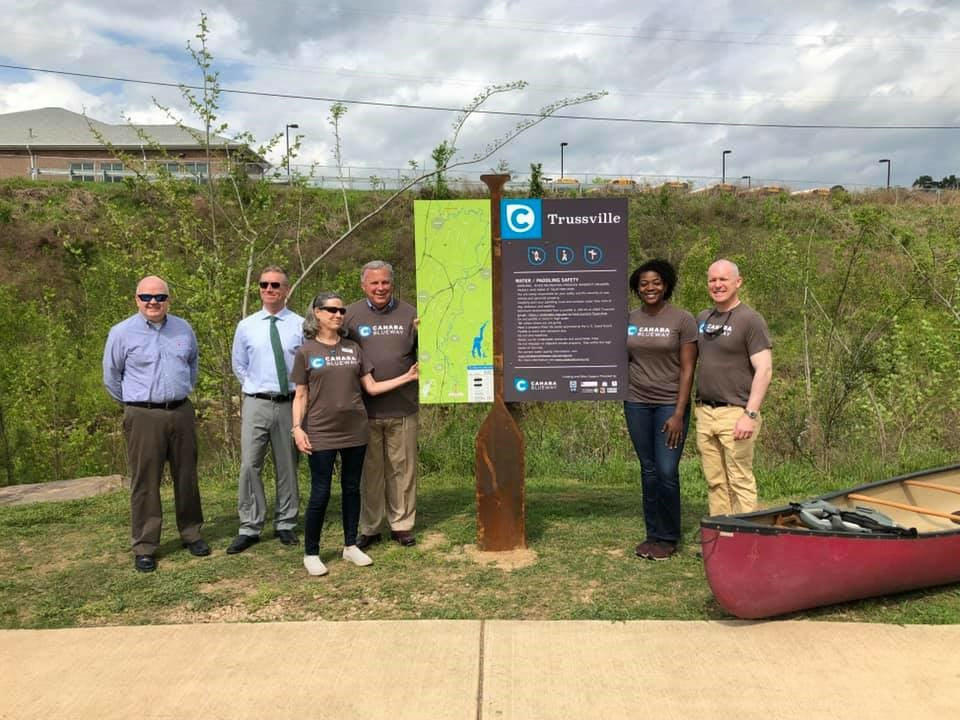 People standing next to upright sign Cahaba Blueway Trussville Greeway